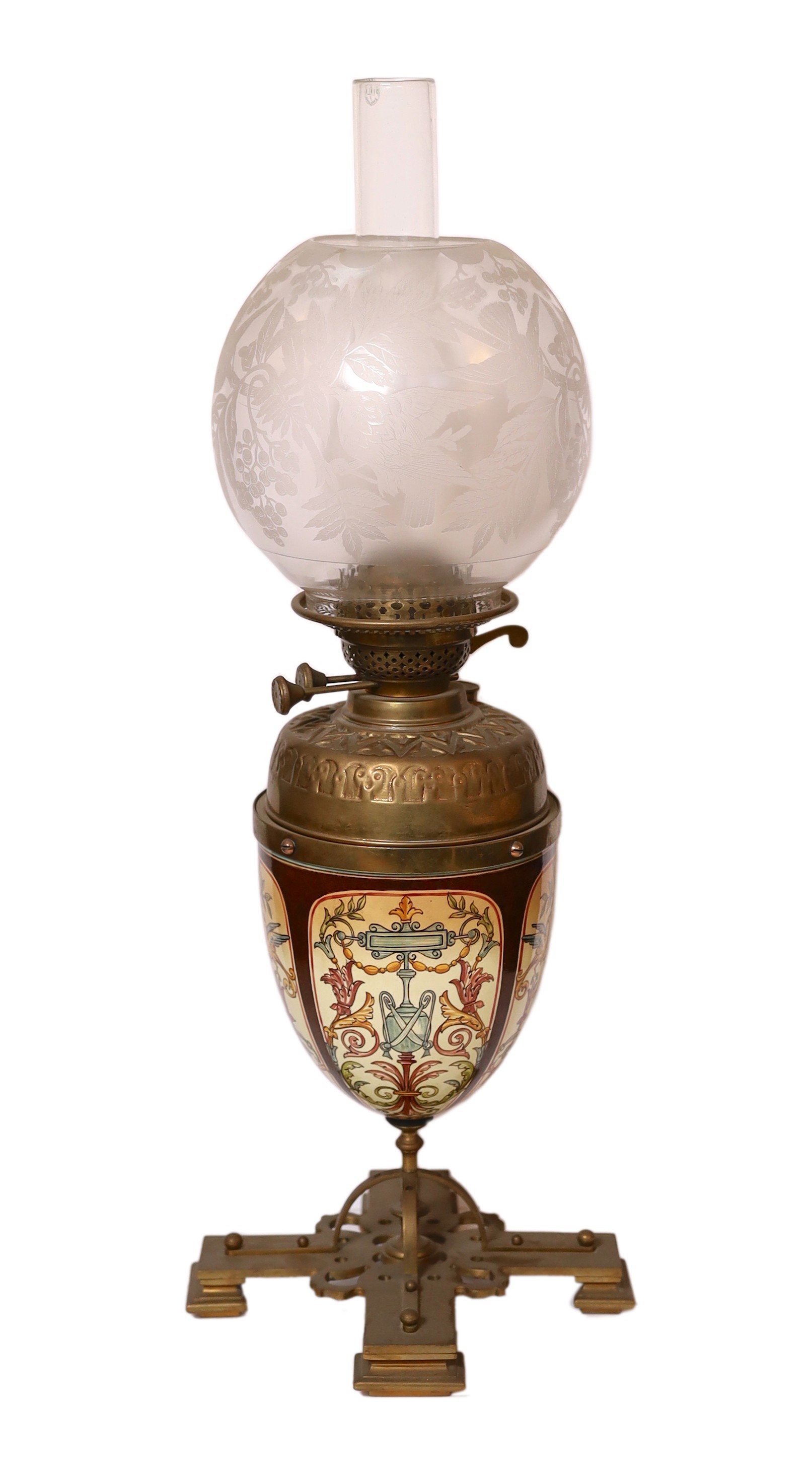 A Victorian brass mounted ceramic oil lamp in the manner of Dalton with brass reservoir and frosted glass shade decorated with birds, height overall 64cm